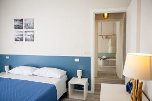 a bedroom with a blue bed and a hallway at Il Confine Azzurro in Porto SantʼElpidio