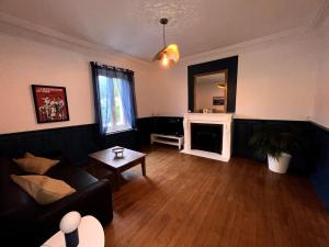 ein Wohnzimmer mit einem schwarzen Sofa und einem Spiegel in der Unterkunft Appartement Coeur du Creusot in Le Creusot + 3 Fotos