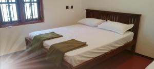 a bedroom with a large bed with white sheets and pillows at coastalcrownvilla in Arugam Bay
