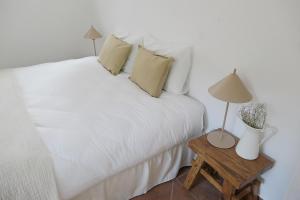 una camera con letto bianco e tavolo con lampada di Manso da Falésia a Olhos de Água Altre 21 foto