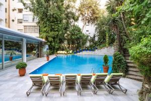 - une piscine avec des chaises et une table en face d'un bâtiment dans l'établissement Marina Bay City Center, à Tanger