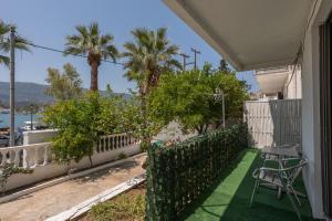 a patio with chairs and palm trees on a house at Blue Lemon Hideaway in Poros +10 photos