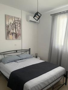 a bedroom with a black and white bed and a window at The twin suites in Nafpaktos