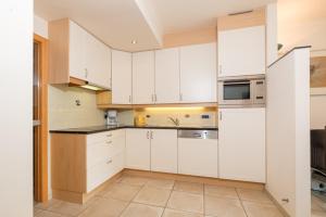 a white kitchen with white cabinets and appliances at Las Palmas 5A in Ostend