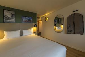 1 dormitorio con 1 cama blanca grande y 2 espejos en Campanile Le Mans Est, en Le Mans