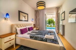a bedroom with a large bed with purple pillows at Villa Bella by Villa Plus in Svetvinčenat +17 photos