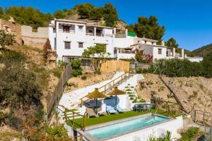 a house on a hill with a swimming pool at Villa Flower in Cómpeta