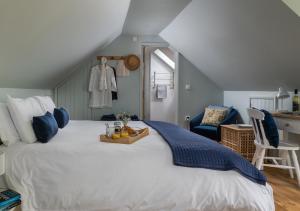 a bedroom with a large white bed and a blue chair at The Old Workshop, Monkton Combe - Elegant Cotswolds Retreat near Bath in Bath +33 photos