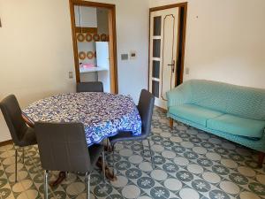 a room with a table and chairs and a couch at Appartamenti Torre Medicea in Castiglioncello