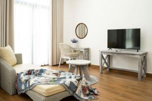 Homestay Đồ Sơn - Cocochi في دو سون: غرفة معيشة مع أريكة وتلفزيون