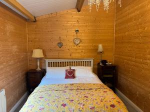 a bedroom with a bed in a wooden room at Shabby Chic Barn in Galway