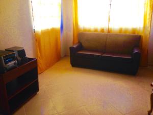 a living room with a couch and a tv at Residencias Bp in Constanza