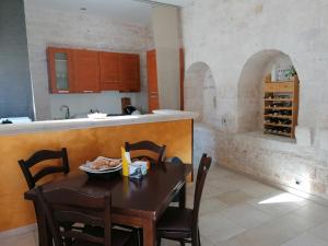 a kitchen with a table with chairs and a counter at B&B Masseria Spilafemine in Turi