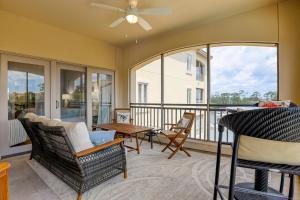 a room with a balcony with chairs and a table at 407 Main Sail in Hilton Head Island