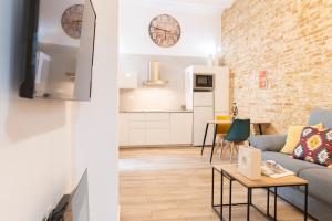 salon i kuchnia z kanapą i stołem w obiekcie Alohamundi Ardilla w Sewilli