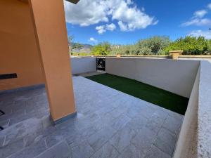 a balcony with a green lawn on it at Trinacria apartments Falcone in Falcone