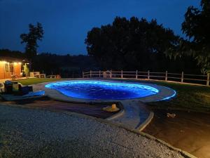 a large blue pool with lights in a yard at night at TUSCANY SUNSET'S ROOM in Capannoli