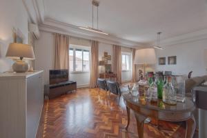 a living room with a table with wine bottles on it at Gaspar House in Lisbon