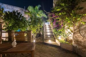 a set of stairs with a wooden table and flowers at Rada room&suite in Favignana +53 photos