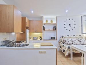a kitchen with a sink and a clock on the wall at Winahost Unió Lloret de Mar in Lloret de Mar