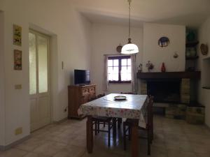 a dining room with a table and a fireplace at Country house La grande quercia in SantʼAntìoco
