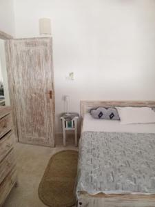 a bedroom with a large bed and a wooden door at Savanna Breeze Villa in Malindi +11 photos