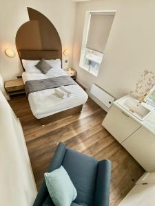 Un dormitorio con una cama y una silla azul. en Design House Peckam - Dynamic City Stay, en Londres