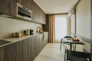 a kitchen with wooden cabinets and a table and a dining room at RAIBU GHENT by STAY-C in Ghent