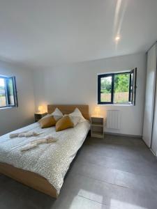 a bedroom with a large bed and two windows at maison Lège cozy in Lège-Cap-Ferret +10 photos