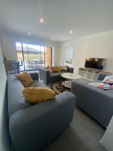 a living room with two couches and a table at maison Lège cozy in Lège-Cap-Ferret