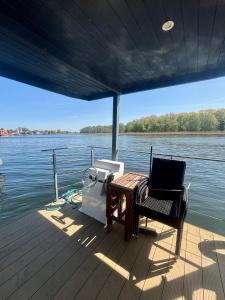 a table and chair on a boat on the water at Dom na wodzie , Morgan in Dziwnów
