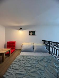a bedroom with a bed and a red chair at Hanoian Traditional Stay - City view - Old Quarter in Hanoi