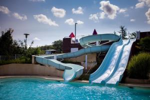 a water slide in a pool at a resort at Camping Domaine le Quercy in Gourdon
