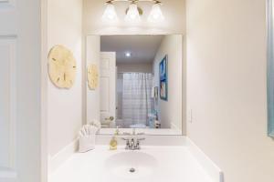 a white bathroom with a sink and a mirror at Bay Dreams --- 31415 Erie Ave in Ocean View +30 photos