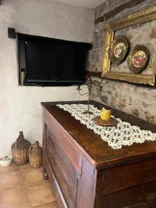 a television on a wall with a table with a candle at Cottage Modrich in Struga +118 photos
