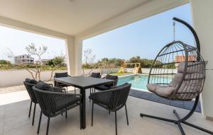 a patio with a swing and a table and chairs at Cozy Home In Turanj With Sauna in Turanj +38 photos