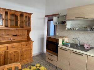 eine Küche mit Holzschränken und einer Spüle in der Unterkunft Marechiaro in Anzio