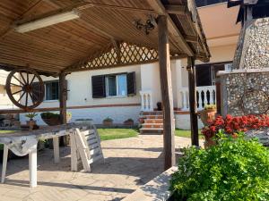 eine hölzerne Pergola mit einem Tisch und einem Rad in der Unterkunft Marechiaro in Anzio