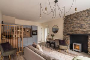 un soggiorno con divano e camino di Ferry View Cottage, 3 bed all en-suite, Hot Tub a Bowness-on-Windermere