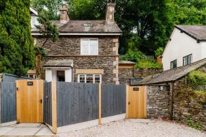 una casa con una recinzione di legno di fronte ad essa di Ferry View Cottage, 3 bed all en-suite, Hot Tub a Bowness-on-Windermere