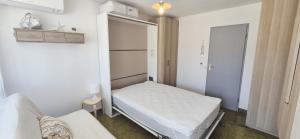 ein kleines Zimmer mit einem Bett und einem Kleiderschrank in der Unterkunft Studio cv, parking, plage 5 mn in La Grande-Motte