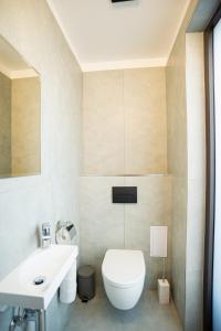 a bathroom with a white toilet and a sink at Exclusive 2-Bedroom Penthouse with Jacuzzi in Budapest