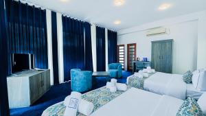 a hotel room with two beds and a television at Hasthi Boutique in Kandy