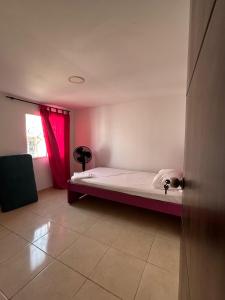a bedroom with a bed with a red curtain at Encantadora casa guajira 1 in Barranquilla