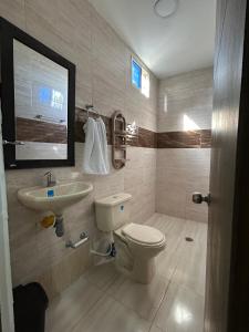 a bathroom with a toilet and a sink at Encantadora casa guajira 1 in Barranquilla +3 photos
