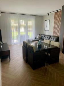 un soggiorno con un divano e un tavolo di MazuryHoliday Apartamenty Kisajno nad jeziorem a Giżycko