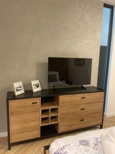 una camera da letto con un comò con una televisione di MazuryHoliday Apartamenty Kisajno nad jeziorem a Giżycko Altre 4 foto
