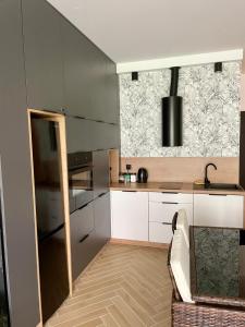una cucina con mobili bianchi e una grande finestra di MazuryHoliday Apartamenty Kisajno nad jeziorem a Giżycko