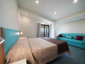 梵蒂冈角Hotel MARINELLA parking wi-fi spiaggia attrezzata的一间卧室，有一张床和一张蓝色沙发