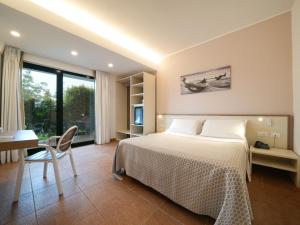 梵蒂冈角Hotel MARINELLA parking wi-fi spiaggia attrezzata的一间卧室，配有一张床、一张桌子和一张书桌